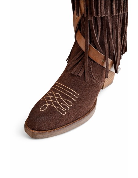 Bota de mujer de piel , alta con flecos y correas de cuero.