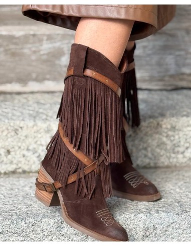 Bota de mujer de piel , alta con flecos y correas de cuero.